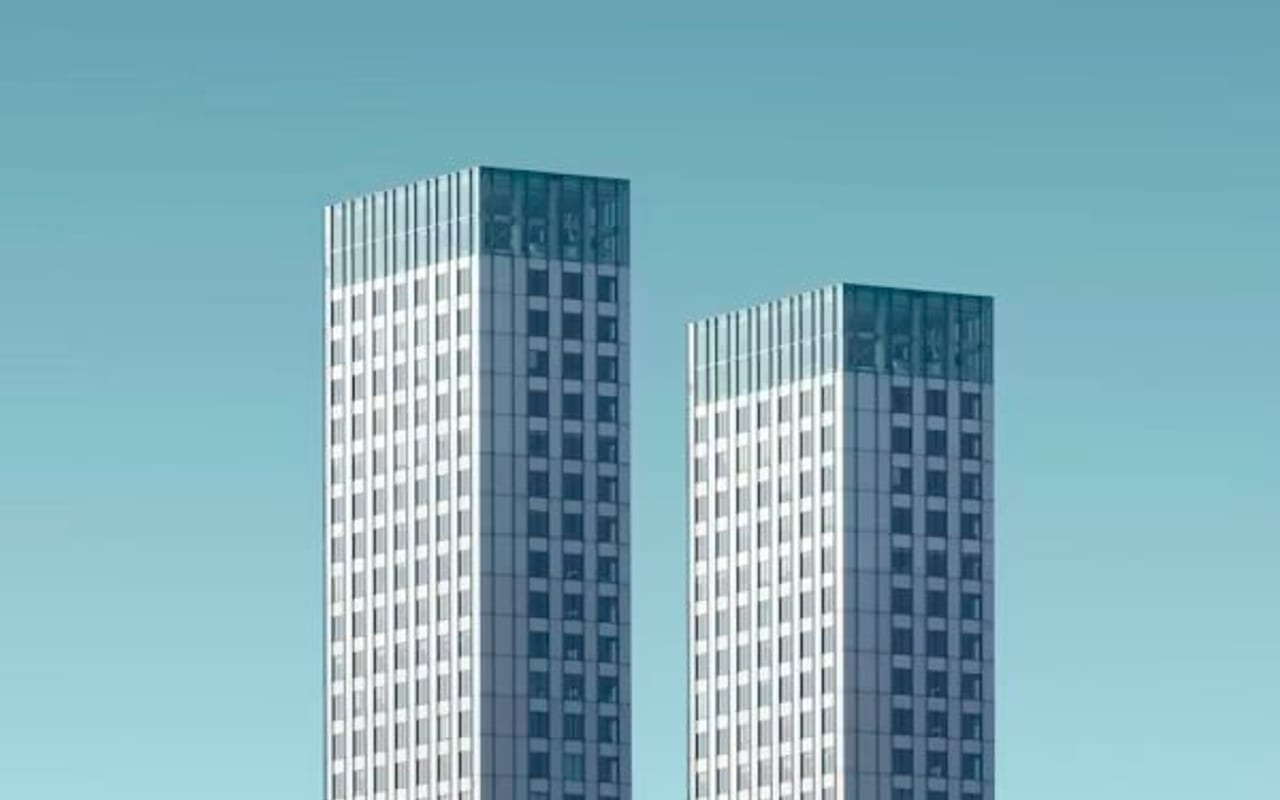 Two modern high-rise buildings against a clear blue sky