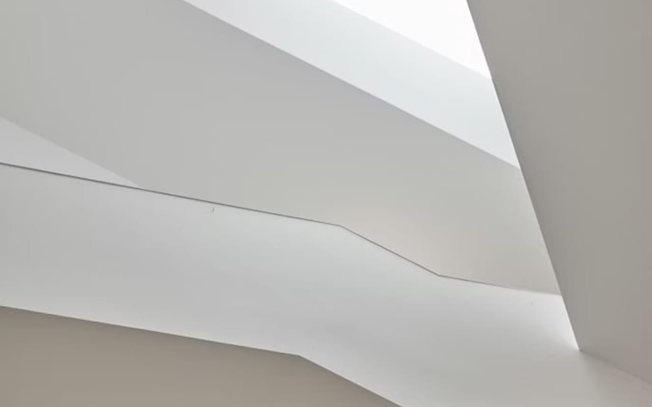 The corner of a modern brick apartment building against a deep blue sky